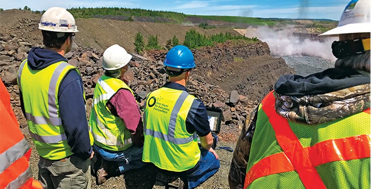 Environmental specialists in high-visibility vests inspecting site conditions