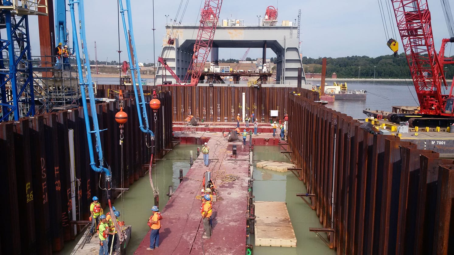 Workers and cranes operating inside a marine cofferdam