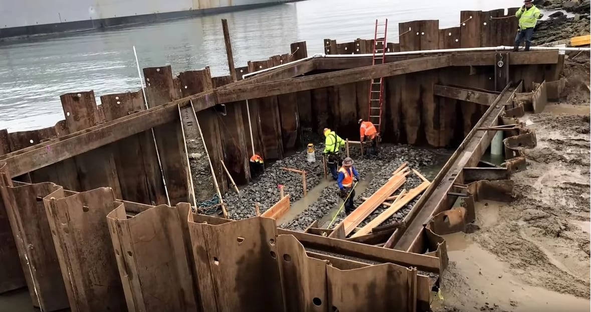 Workers inside a structural cavity of a bridge foundation