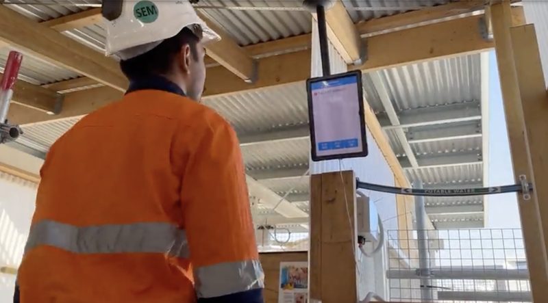Worker checking an automated status screen inside a site facility
