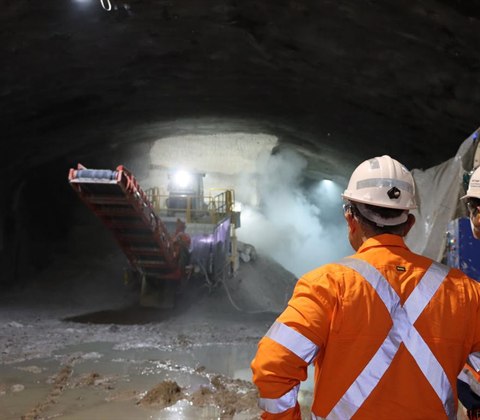 Underground mine crew observing a loader working at the face