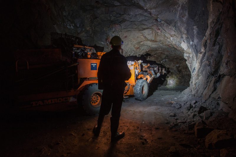 Miner watching a loader working underground