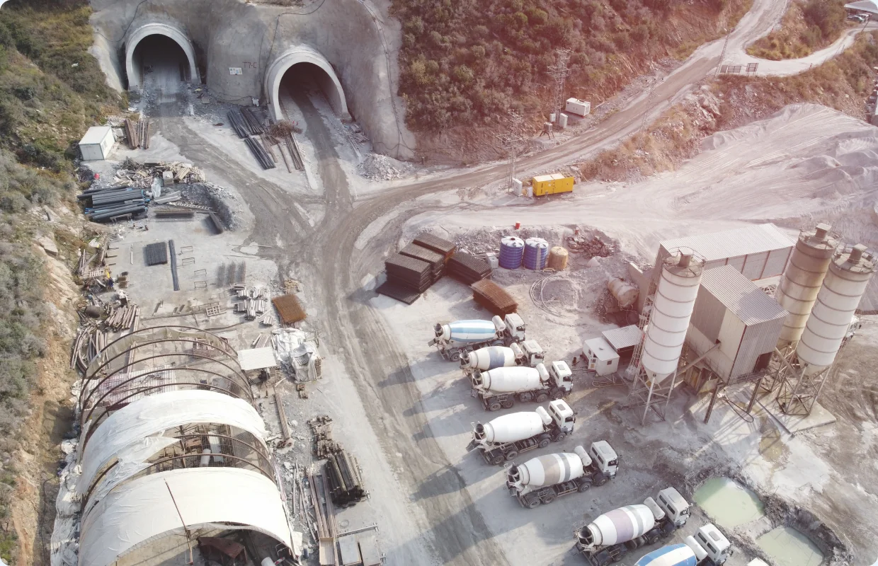 Aerial view of a tunnelling site with twin tunnel portals, concrete agitator fleet and batch plant